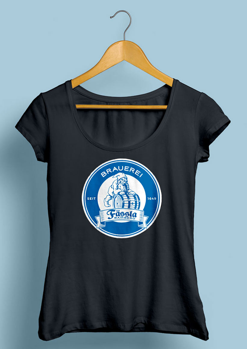 Schwarzes T-Shirt der Brauerei Fässla Bamberg mit blau-weißem runden Logo mittig auf der Brust, welches einen Zwerg, der ein Bierfass rollt und den Schriftzug der Brauerei enthält.